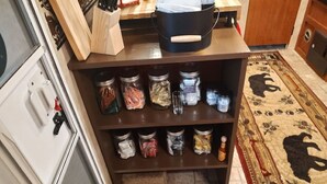 A kitchen with multiple shelves holding jars of spices and condiments. - Get away and get back to nature! (East Nassau)