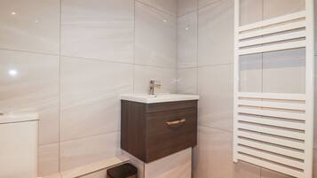 Une salle de bain moderne équipée de toilettes, d’un lavabo et d’un meuble-lavabo.