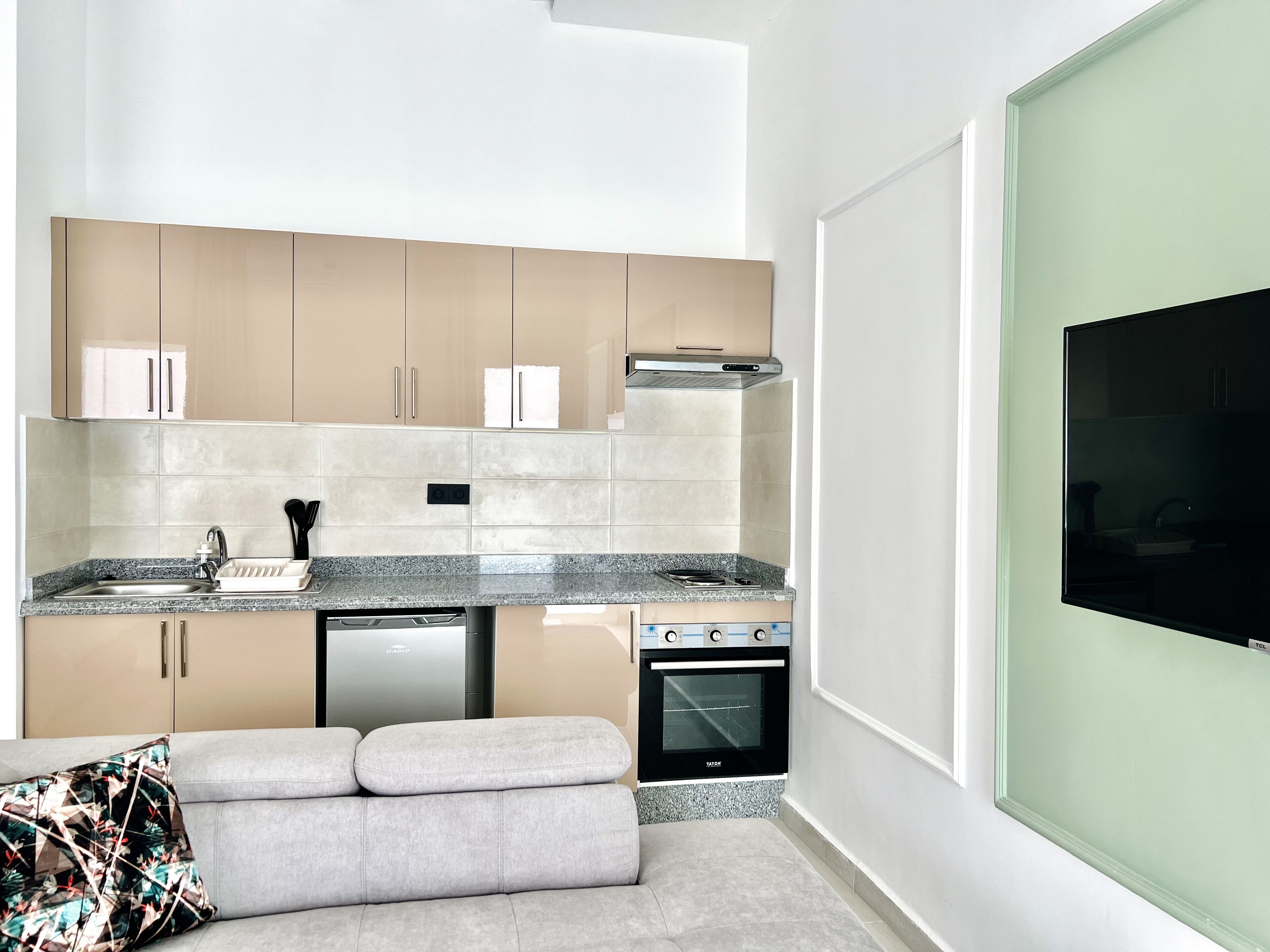 Una cocina moderna con horno integrado, lavavajillas y un amplio ventanal que proporciona luz natural.