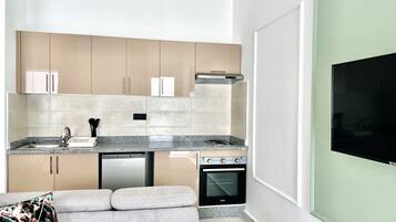 Una cocina moderna con horno integrado, lavavajillas y un amplio ventanal que proporciona luz natural.