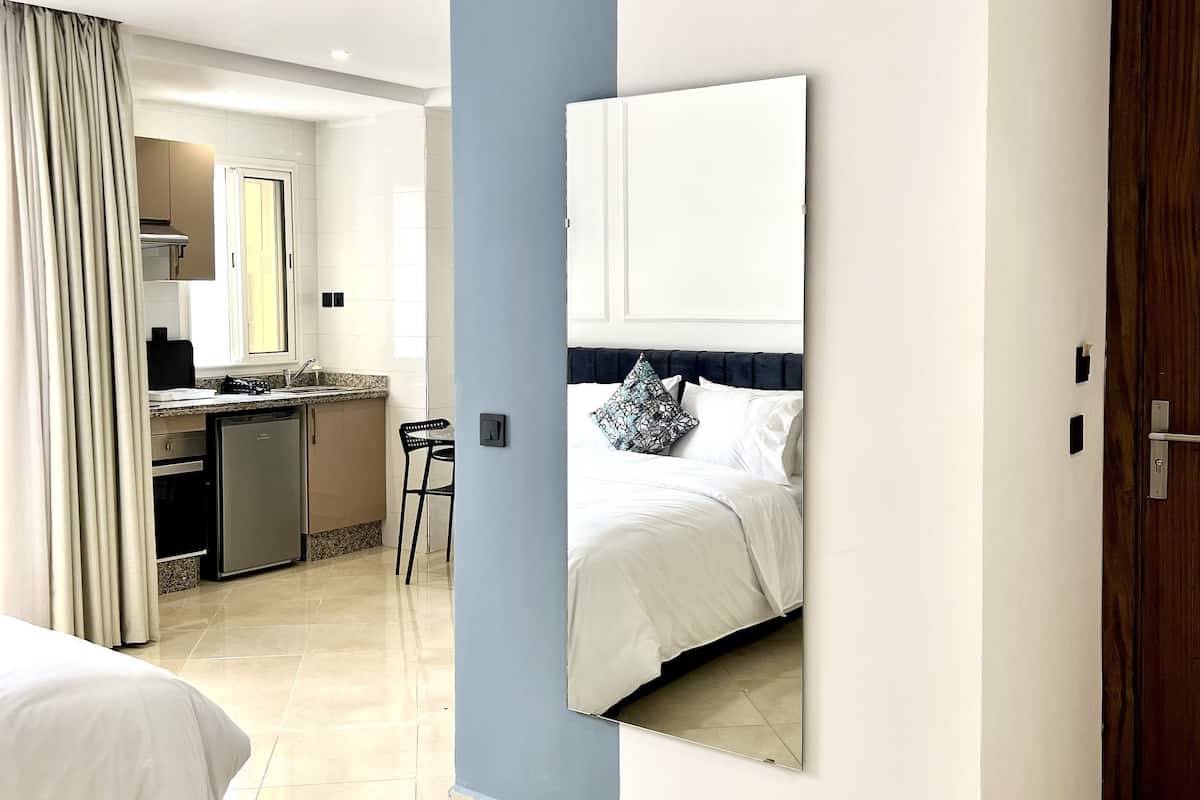 Una habitación de hotel con cama, escritorio y kitchenette.
