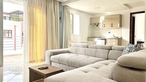 A modern living room with a sectional sofa, a coffee table, and a kitchen in the background. - MyCity (Rabat)