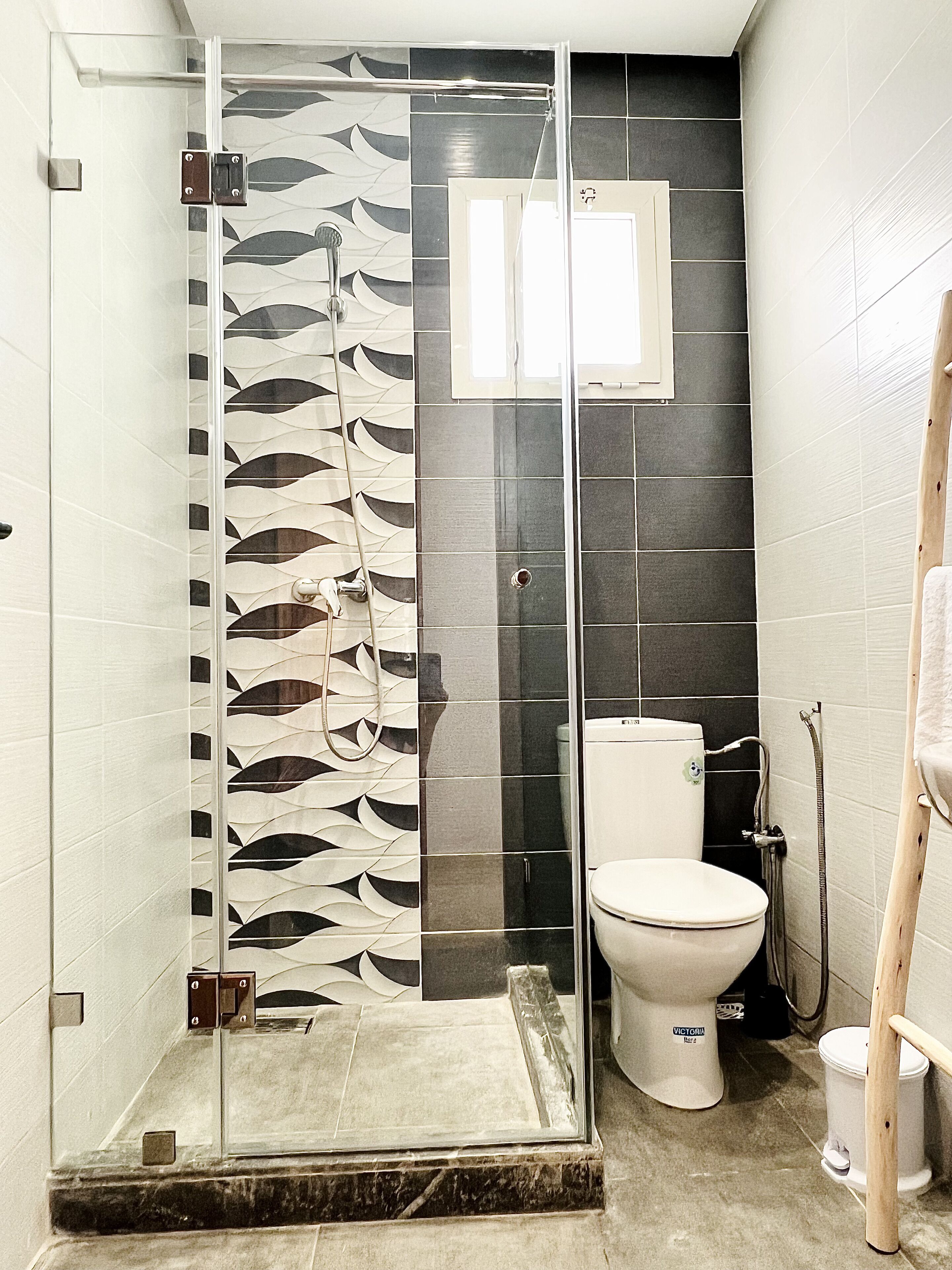Un baño con cabina de ducha de vidrio, inodoro y lavabo.