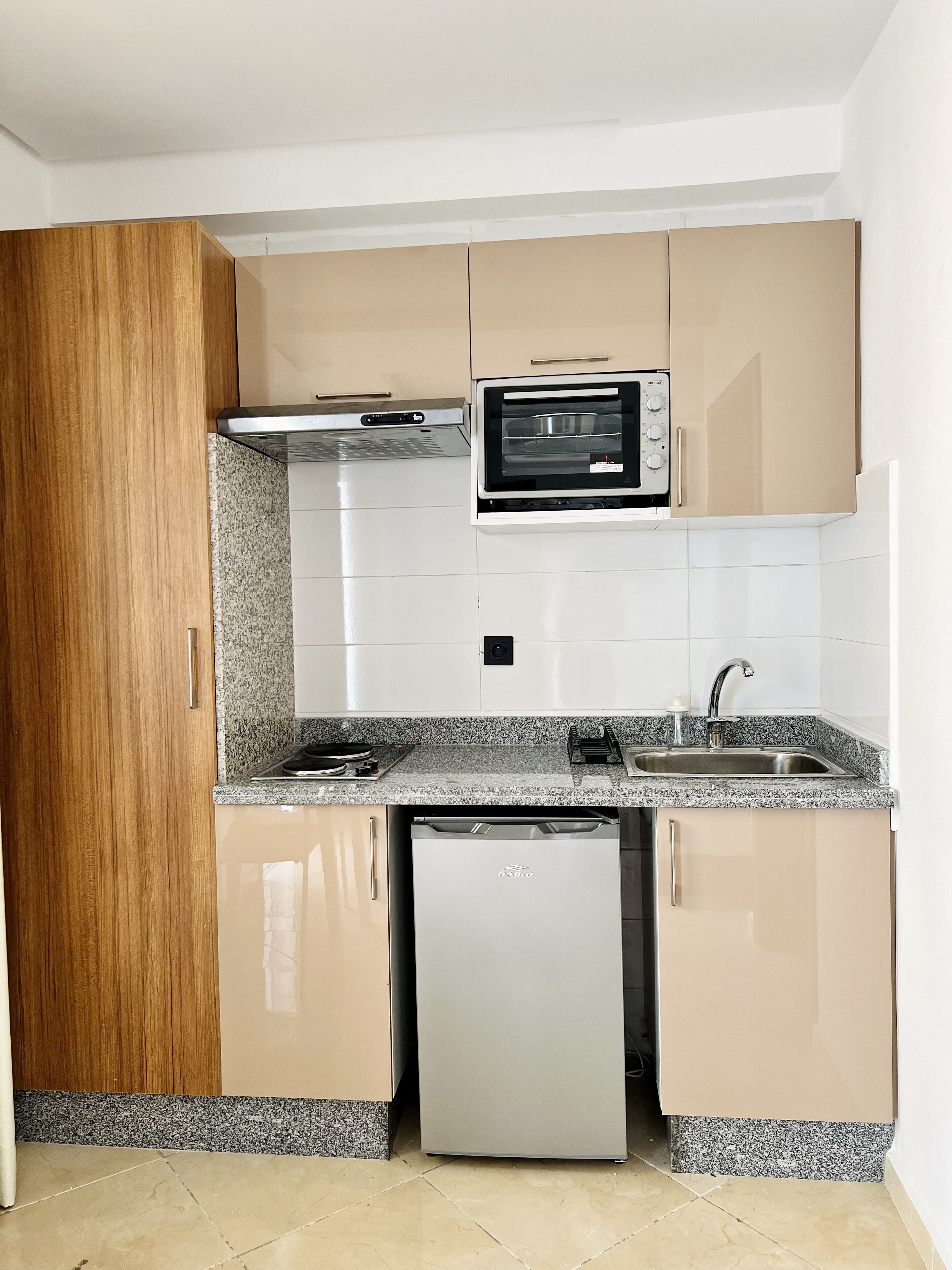Cocina compacta con horno, microondas y lavavajillas integrados.