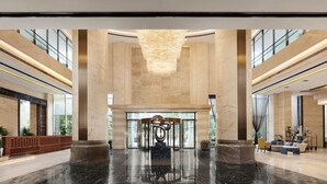 A spacious lobby with a high ceiling, marble columns, a large chandelier, and a central sculpture. - Crowne Plaza Dujiangyan by IHG (Chengdu)