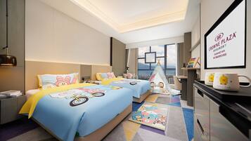 A hotel room with two beds, a desk, a chair, a window with a city view, and a sign for Crowne Plaza Dujang.