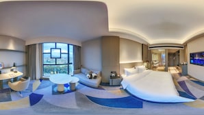 A modern hotel room with a large bed, a sofa, a dining table, and a TV. - Crowne Plaza Dujiangyan by IHG (Chengdu)