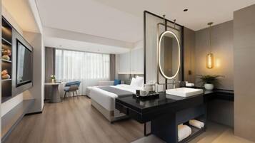 A modern hotel room with a large bed, a desk with a mirror, a separate bathroom with a vanity, and a seating area with a chair and table.