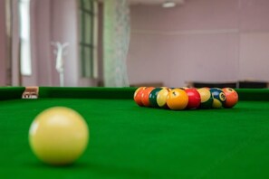 A pool table with a yellow cue ball and a striped arrangement of billiard balls. - Hongyuan Hotel (Gucheng)