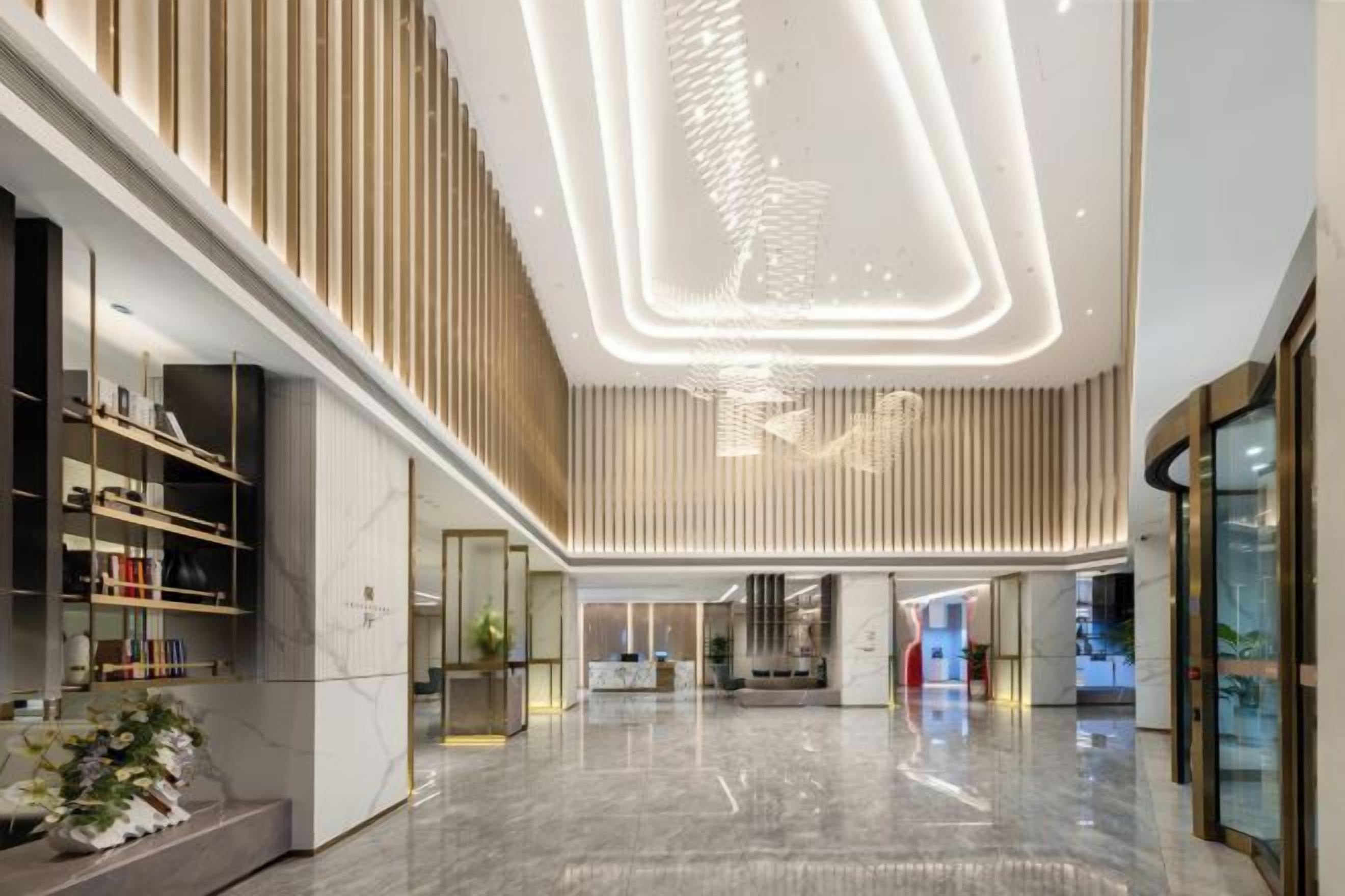 A spacious interior with a high ceiling, modern lighting, and a central reception area.