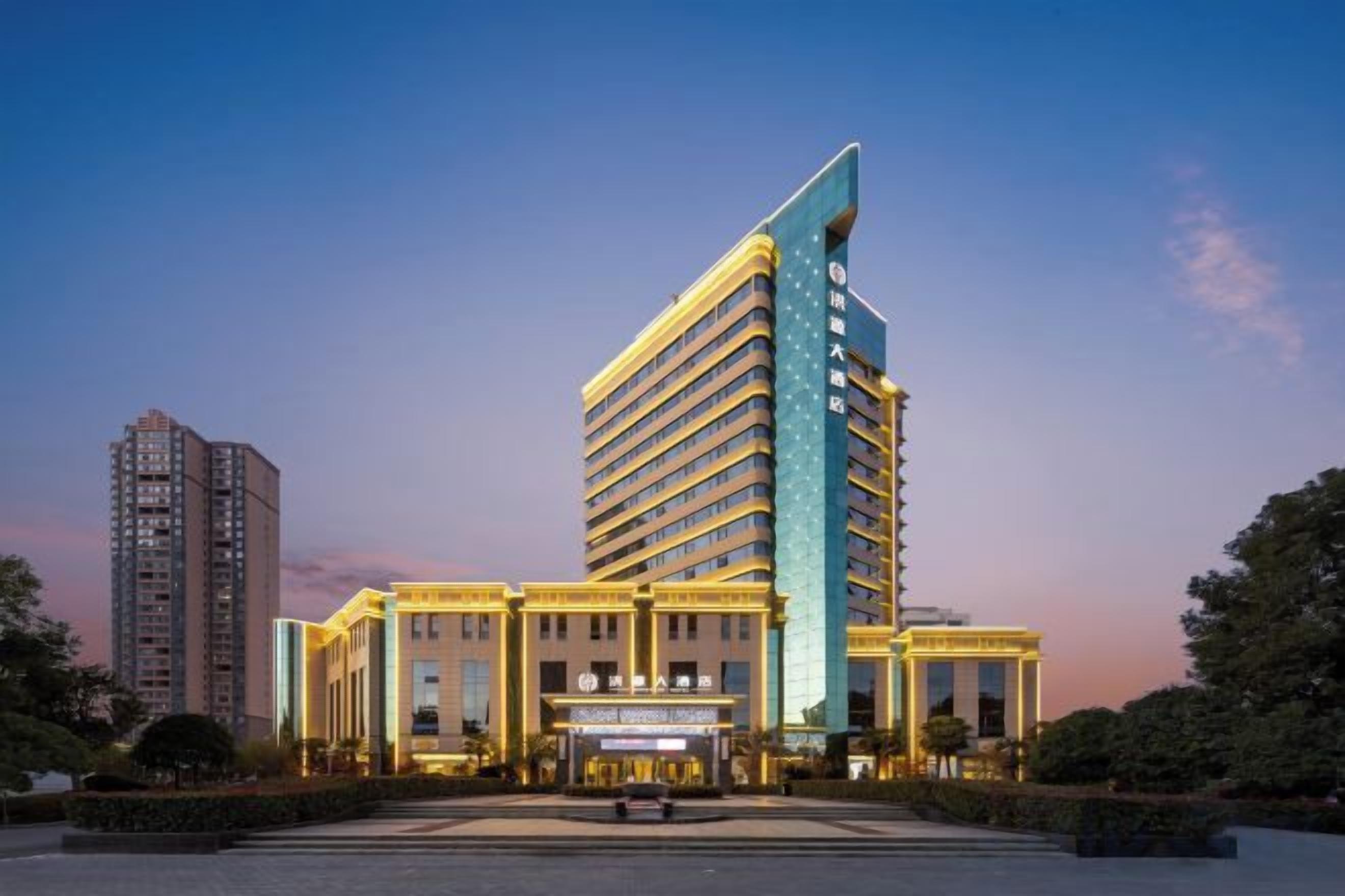 A multi-story hotel with a prominent vertical structure, a central entrance, and a well-maintained outdoor area.