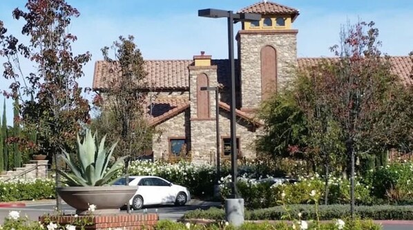 A building with a stone facade, a tower, and a car parked in front.