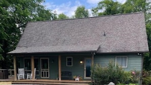 A single-story house with a porch, a concrete driveway, and a well-maintained lawn. - Creekside a piece of heaven (Gallipolis)