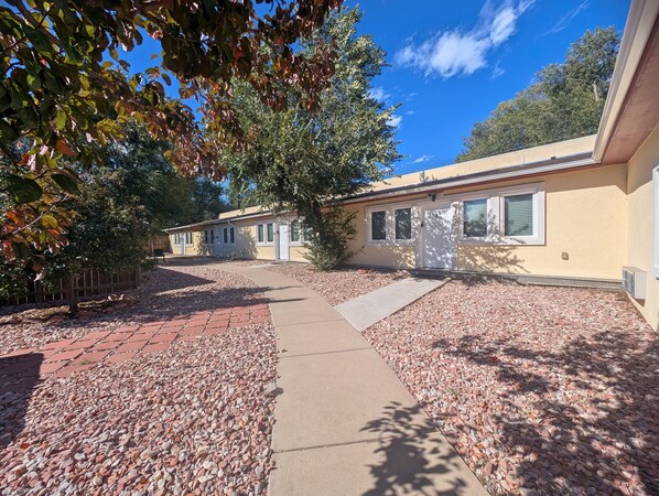 A row of single-story mobile homes with a paved driveway and gravel ground. - Hot Tub Cozy Cottage in Colorado Springs (Colorado Springs)