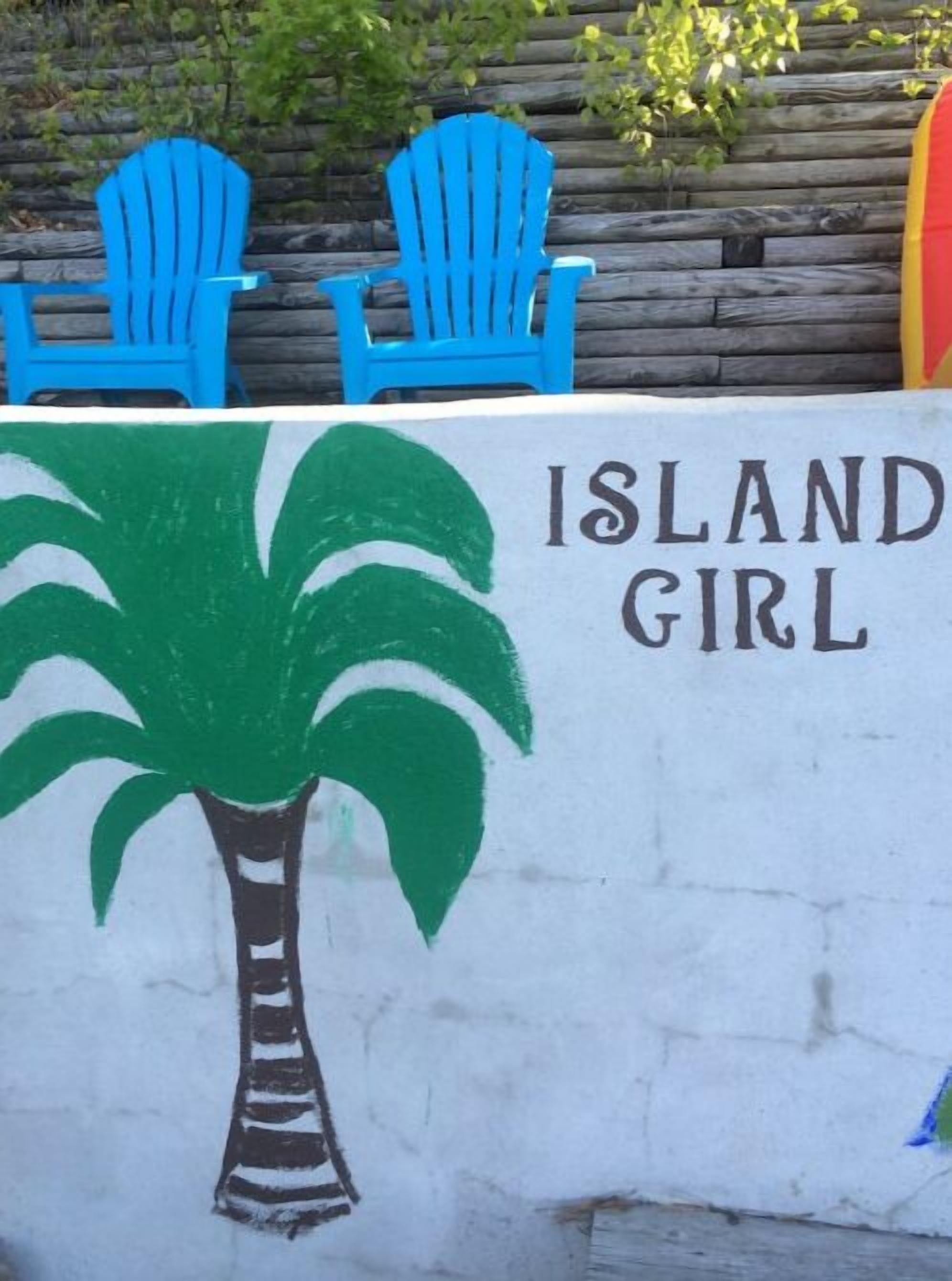 Eine Wand mit einer Palme und dem Schriftzug "ISLAND GIRL".