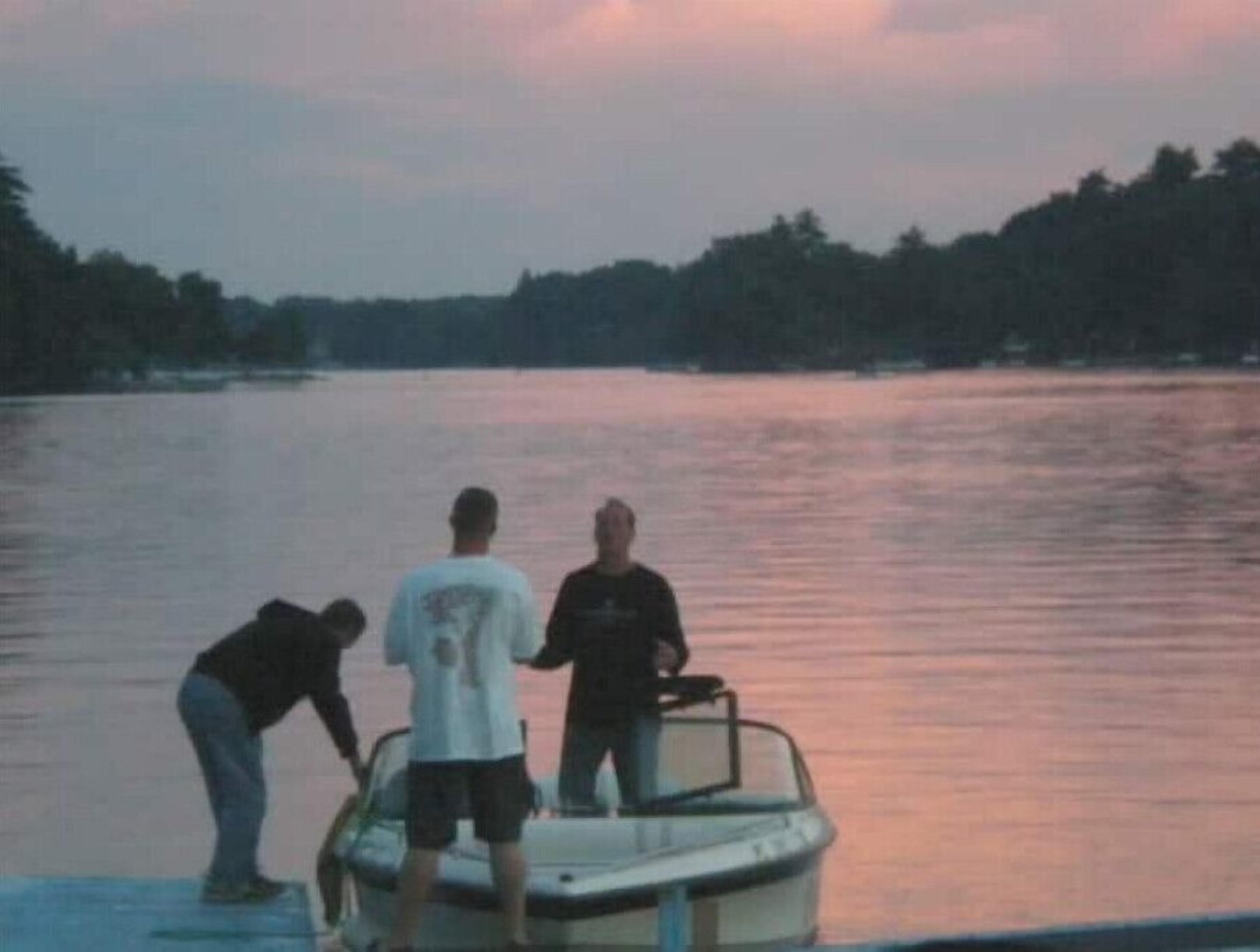 A group of people on a boat at dusk.