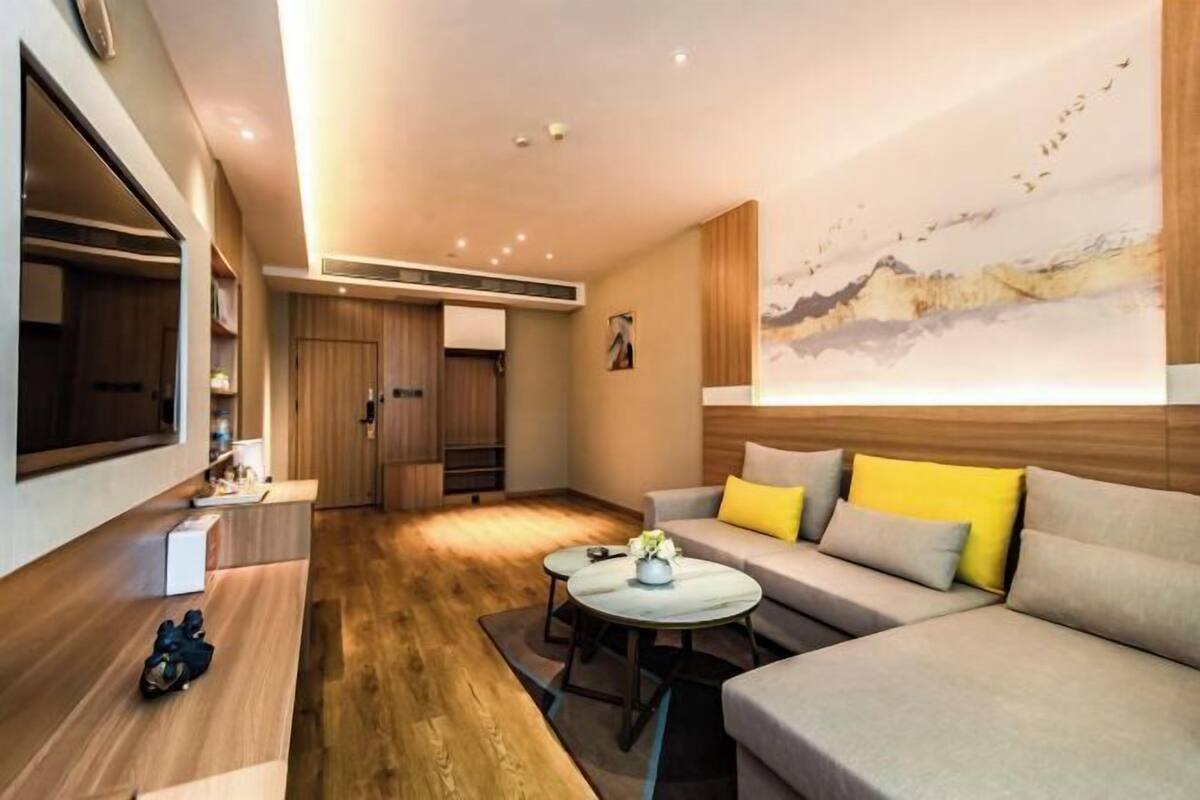 A modern living room with a sofa, coffee table, and artwork on the wall.