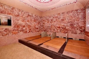 A spa room with stone walls, a wooden floor, and a seating area.