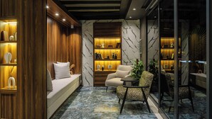 Un interior moderno con sofá, sillón y separador de vidrio.