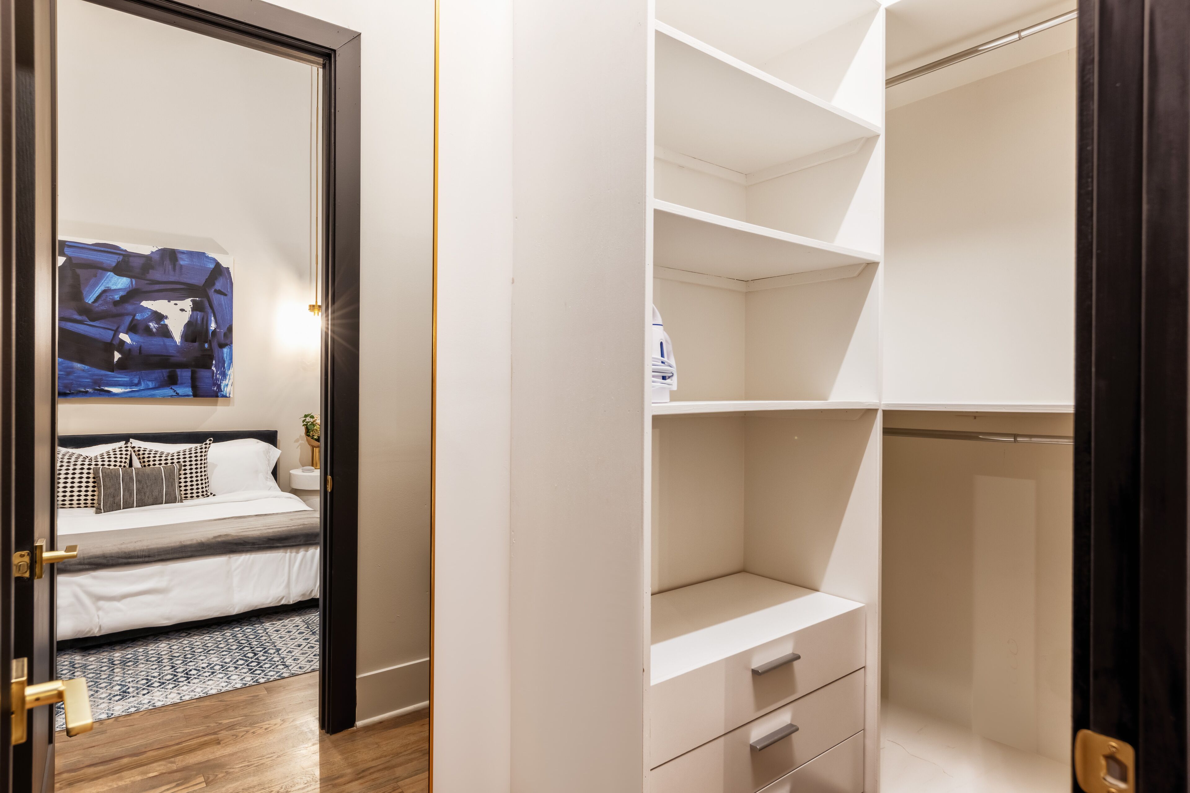 Ein Schlafzimmer mit Bett, Nachttisch und Wandbild.