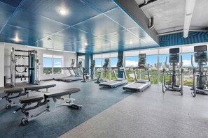 A gym with treadmills, elliptical machines, and weight benches.