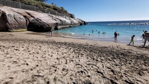 A beach with rocky cliffs and clear blue water. - Home2Book Chill & Sun Colina Blanca & Pool, Adeje (Adeje)
