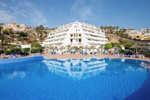 A large hotel with a swimming pool, multiple balconies, and a hillside view. - Home2Book Chill & Sun Colina Blanca & Pool, Adeje (Adeje)