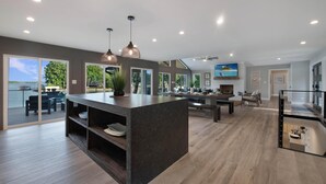 A spacious kitchen with a large island, pendant lighting, and a view of the outdoors. - Lakeshore Adrift (Denver)