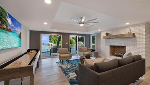 A spacious living room with a wooden coffee table, a brown sofa, and a fireplace. - Lakeshore Adrift (Denver)