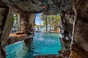 Una piscina natural de roca con agua cristalina, rodeada de grandes formaciones rocosas.