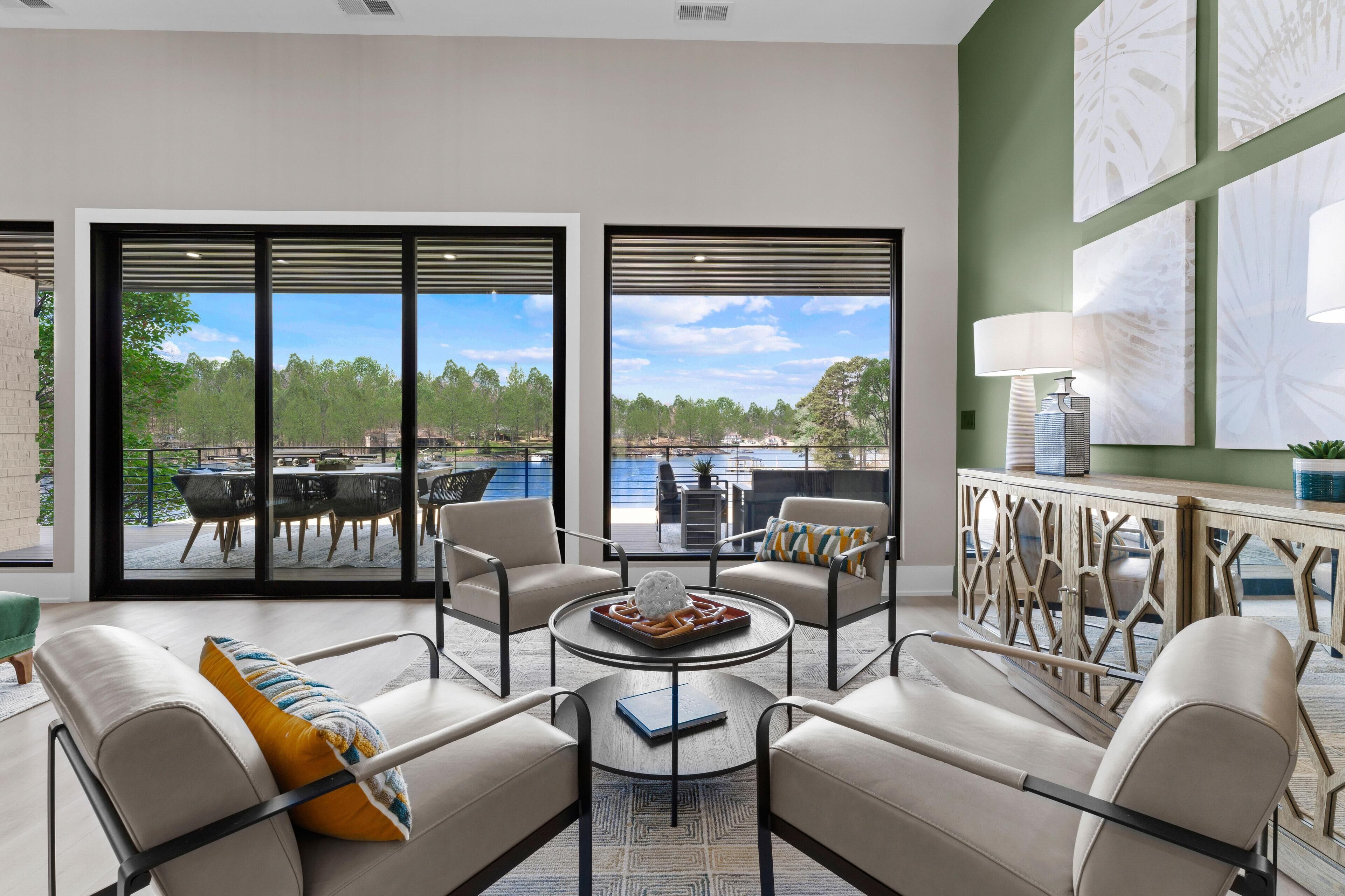 A modern living room with a view of a pool and outdoor seating area.
