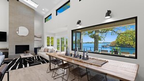 Una cucina moderna con un'isola grande, un camino e vista su un lago.