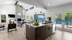 Un'ampia cucina con una grande isola, elettrodomestici moderni e vista sull'esterno.
