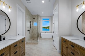 Une salle de bain moderne avec deux lavabos, une douche et une baignoire.