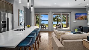 Una cocina moderna con una isla grande, taburetes de bar y vistas al exterior.