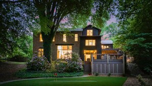 A two-story house with a well-maintained garden and a wooden deck.