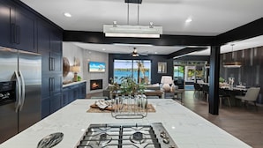 A modern kitchen with a central island, stainless steel appliances, and a fireplace. - Channel Marker (Mooresville)