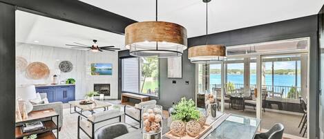 Un intérieur moderne comprenant un coin repas, une cuisine et un balcon avec vue sur la mer.