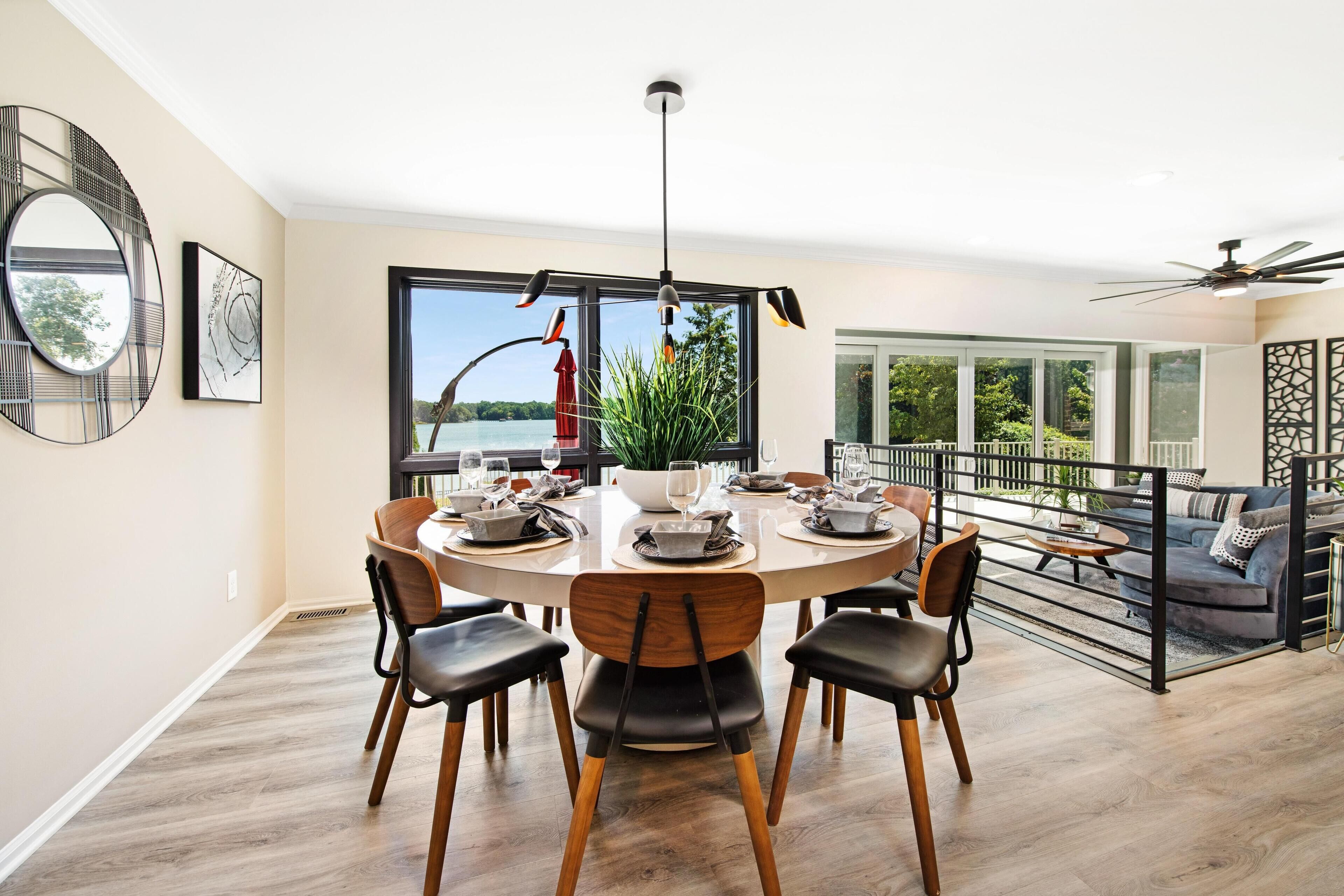 A modern dining area with a round table, chairs, and a view of the outdoors.