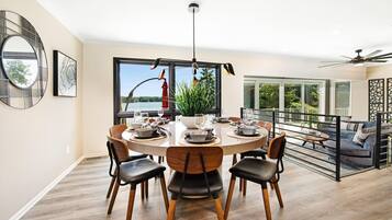 A modern dining area with a round table, chairs, and a view of the outdoors.