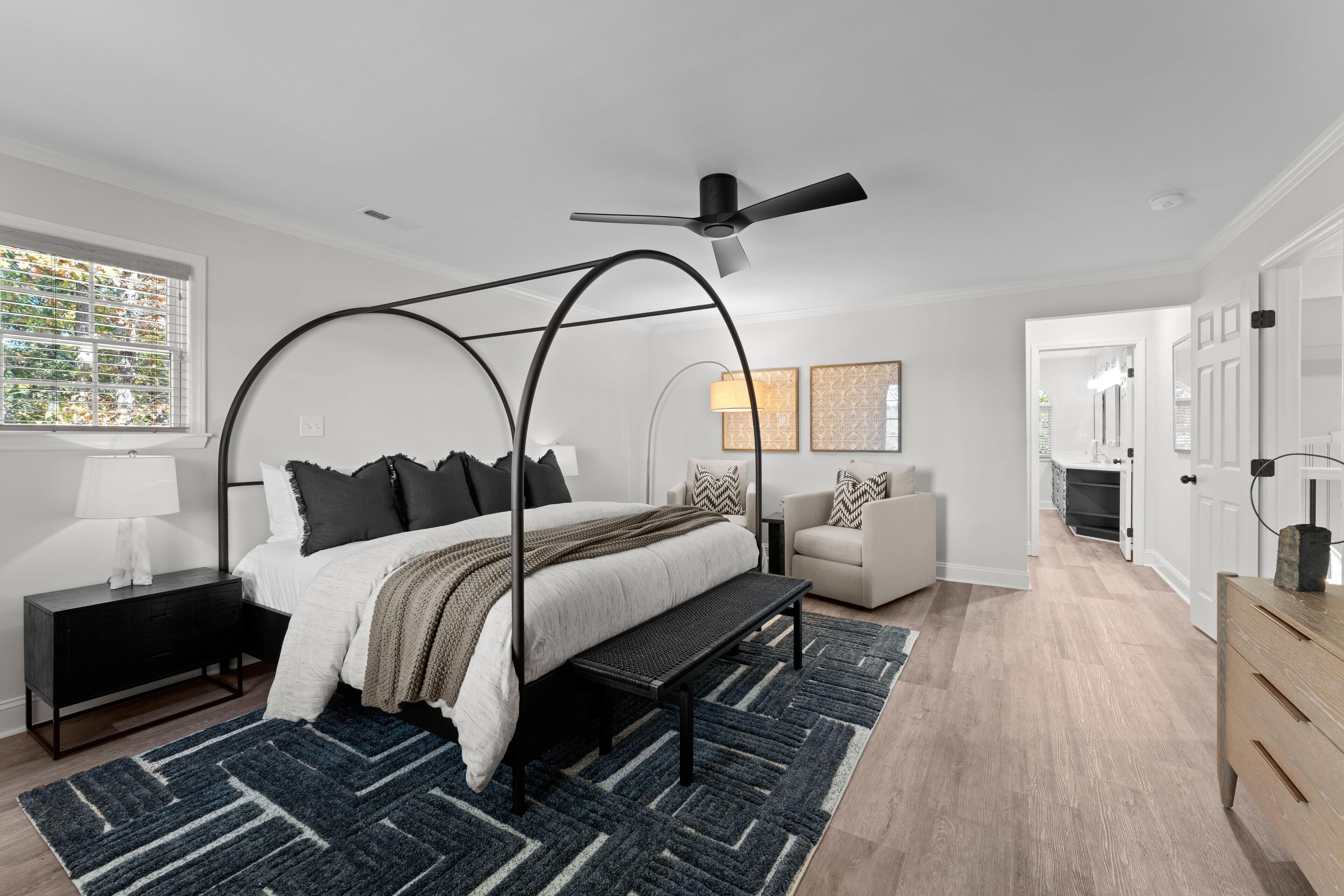 Ein modernes Schlafzimmer mit einem Himmelbett, einem Stehpult und einem Deckenventilator.