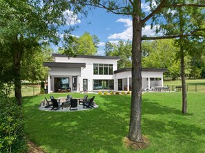 A modern two-story house with a patio area featuring outdoor furniture. - Shoreline on Stonemarker (Mooresville)