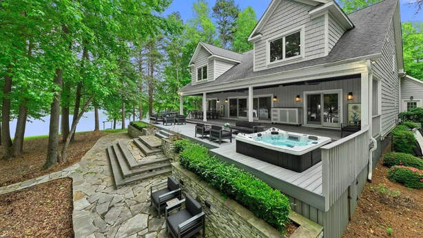 A two-story house with a covered patio, outdoor seating, and a hot tub. - Grand Bay W/hot Tub, 440' Shoreline & Optional Boat Rental (Mooresville)