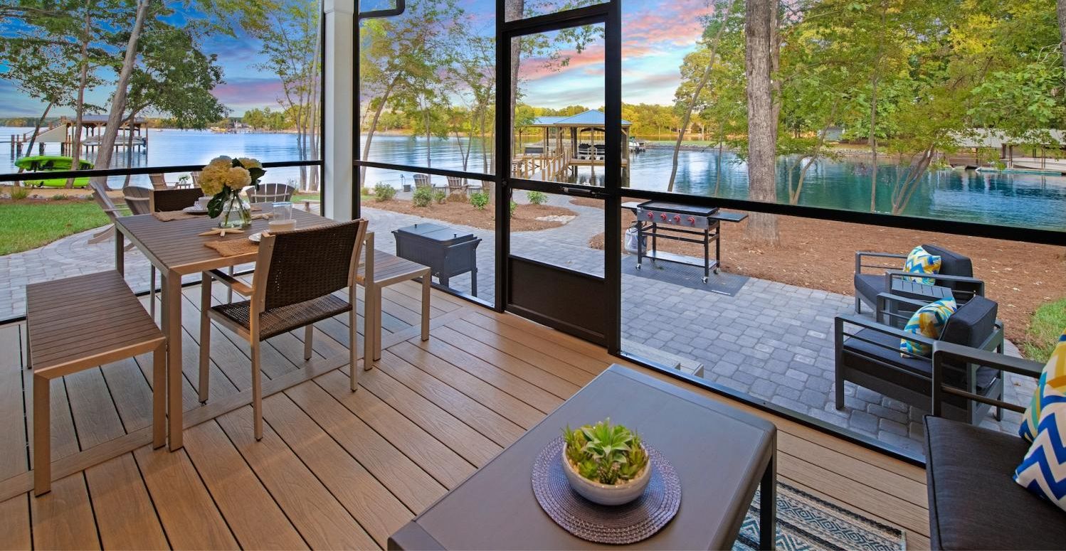 A modern room with large windows overlooking a lake, featuring 9 beds and 12 sleeping areas.