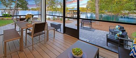 A modern room with large windows overlooking a lake, featuring 9 beds and 12 sleeping areas.
