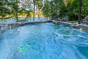Ein Whirlpool, umgeben von Bäumen mit Blick auf einen See.