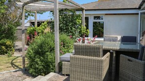A covered outdoor seating area with wicker furniture and a pergola structure. - 50 Harbour Road (Bognor Regis)