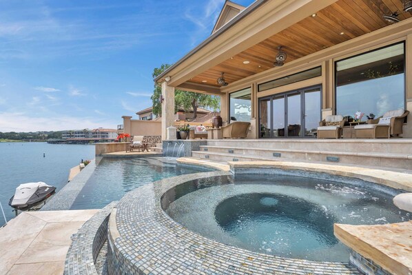 A pool with a wooden deck and outdoor seating.