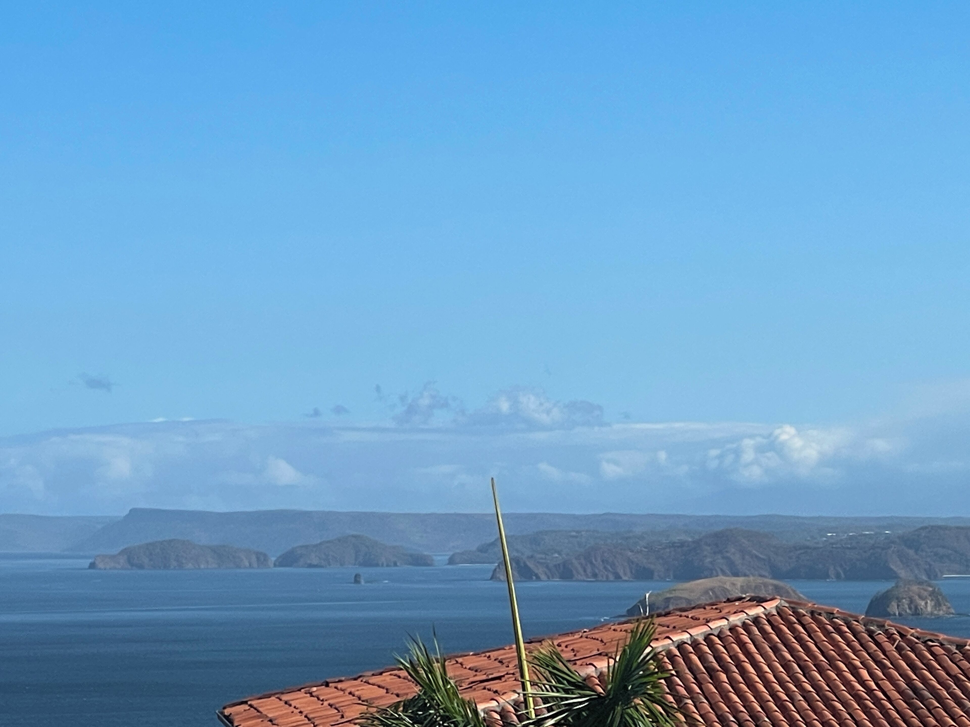 A coastal view with a tiled roof and a clear sky.