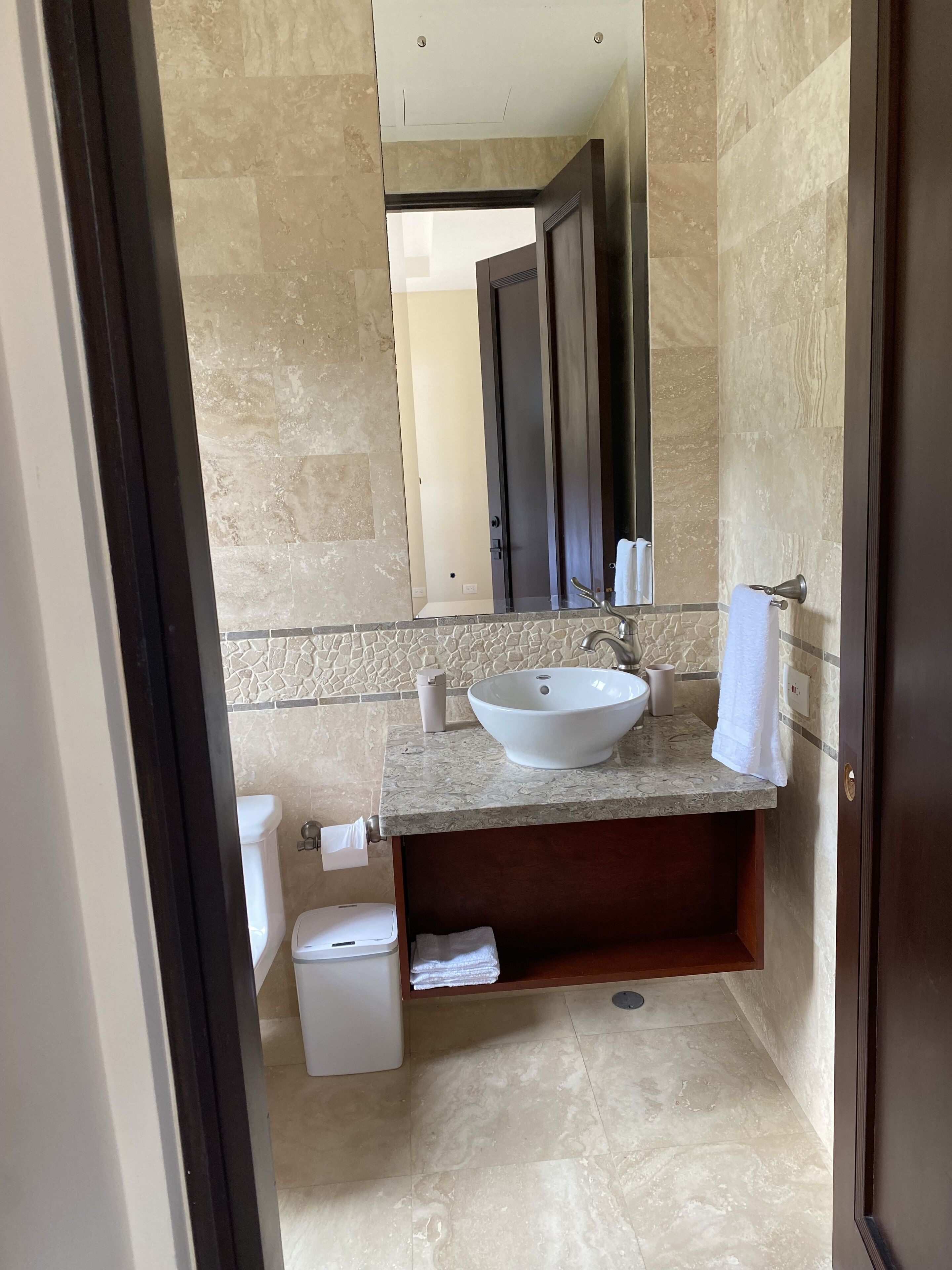 Ein modernes Badezimmer mit einem großen Waschbecken, einem Spiegel und einer Toilette.